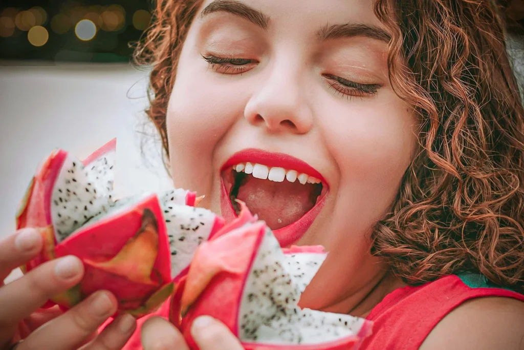 mulher-sorridente-segurando-frutas-de-dragao